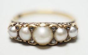 A late Victorian yellow metal (stamped 18) and five stone graduated split pearl set half hoop