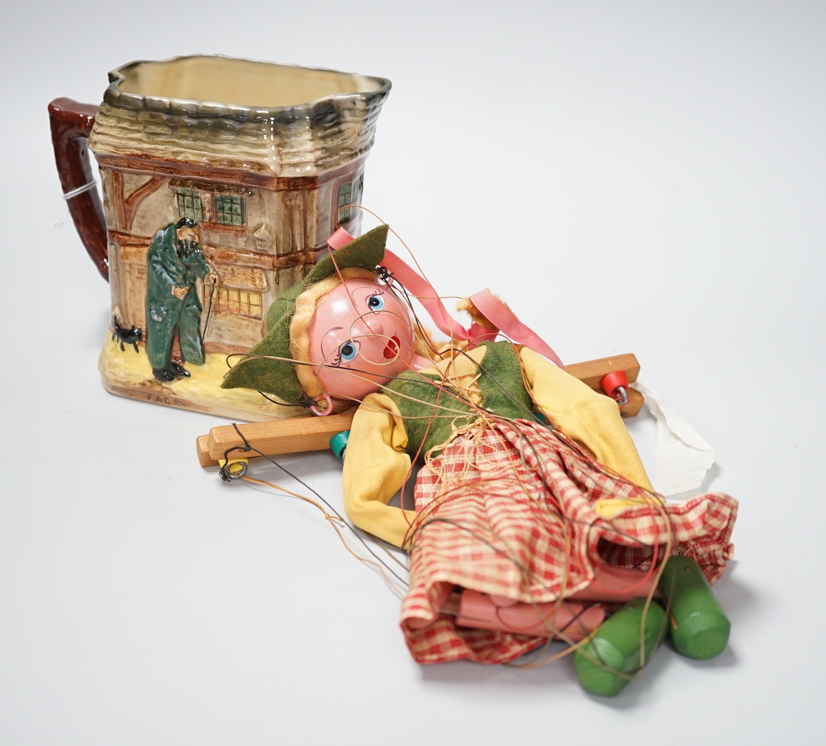 A Doulton Oliver Twist series ware jug and a Pelham puppet