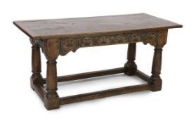 A 17th century style oak refectory table, with lunette carved frieze and cannon barrel legs united