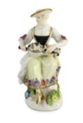 A Meissen porcelain figure of a woman playing the hurdy gurdy, mid 18th century, possibly modelled