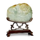 A Chinese three colour jade 'Buddhist lion' belt buckle, 19th century, carved in low relief with the