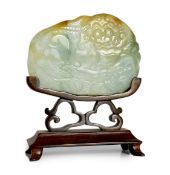 A Chinese three colour jade 'Buddhist lion' belt buckle, 19th century, carved in low relief with the