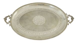 An Edwardian silver two handled oval tea tray, by Mappin & Webb, with scrollwork handles, beaded