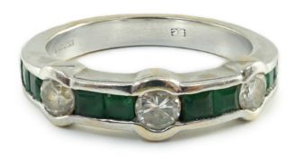 A modern 18ct white gold, three stone collet set diamond and eight stone channel set emerald half