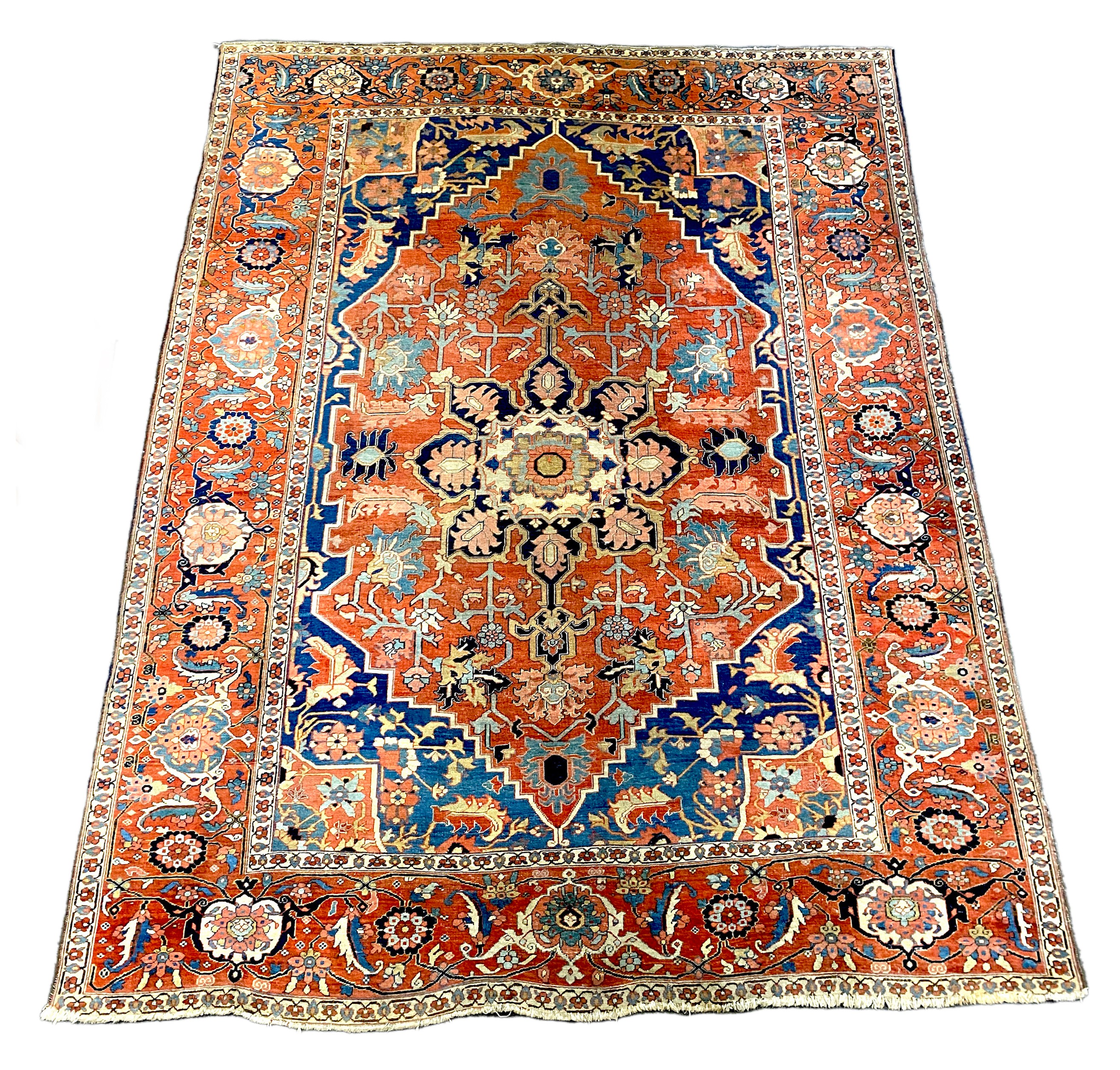 An antique Heriz brick red ground carpet, with large central floral medallion within a wide