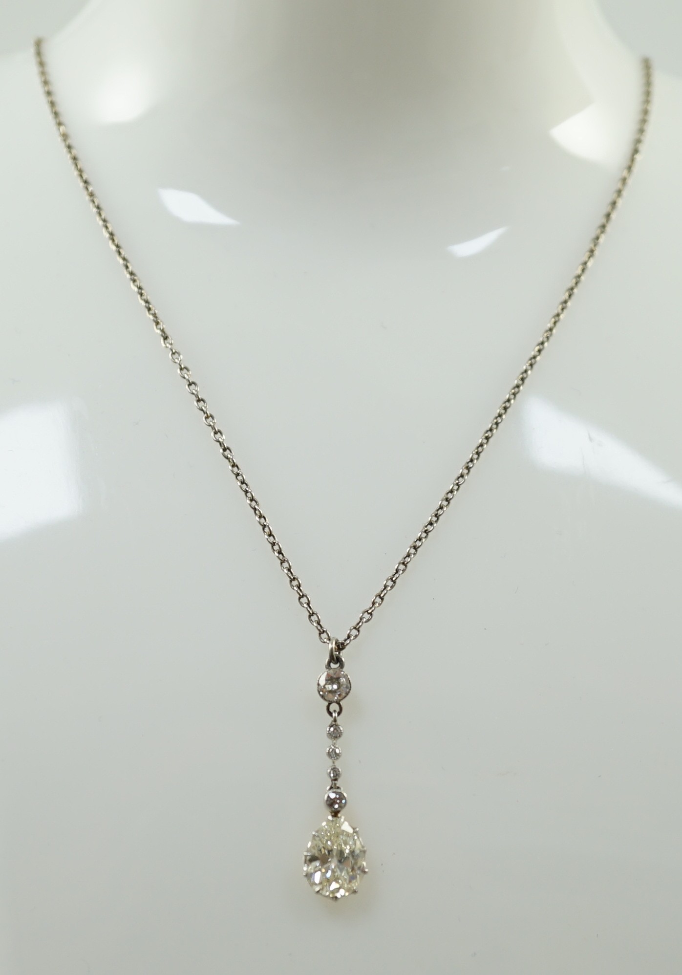 An early to mid 20th century white and yellow gold, six stone diamond set drop pendant, on a white - Image 5 of 5