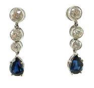 A pair of 1980's platinum, single stone pear cut sapphire and graduated three stone collet set