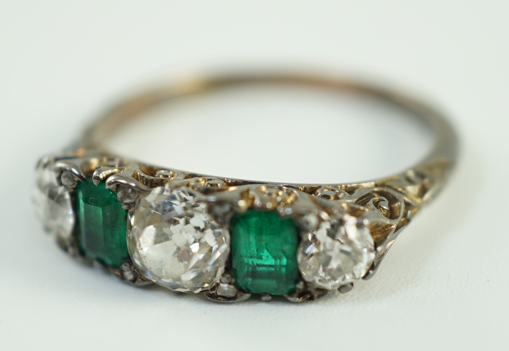 An early 20th century 18ct gold, three stone diamond and two stone emerald set half hoop ring, - Image 7 of 10
