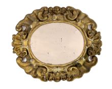 An 18th century Baroque giltwood wall mirror, of oval scrolling cartouche form, with scallop shell