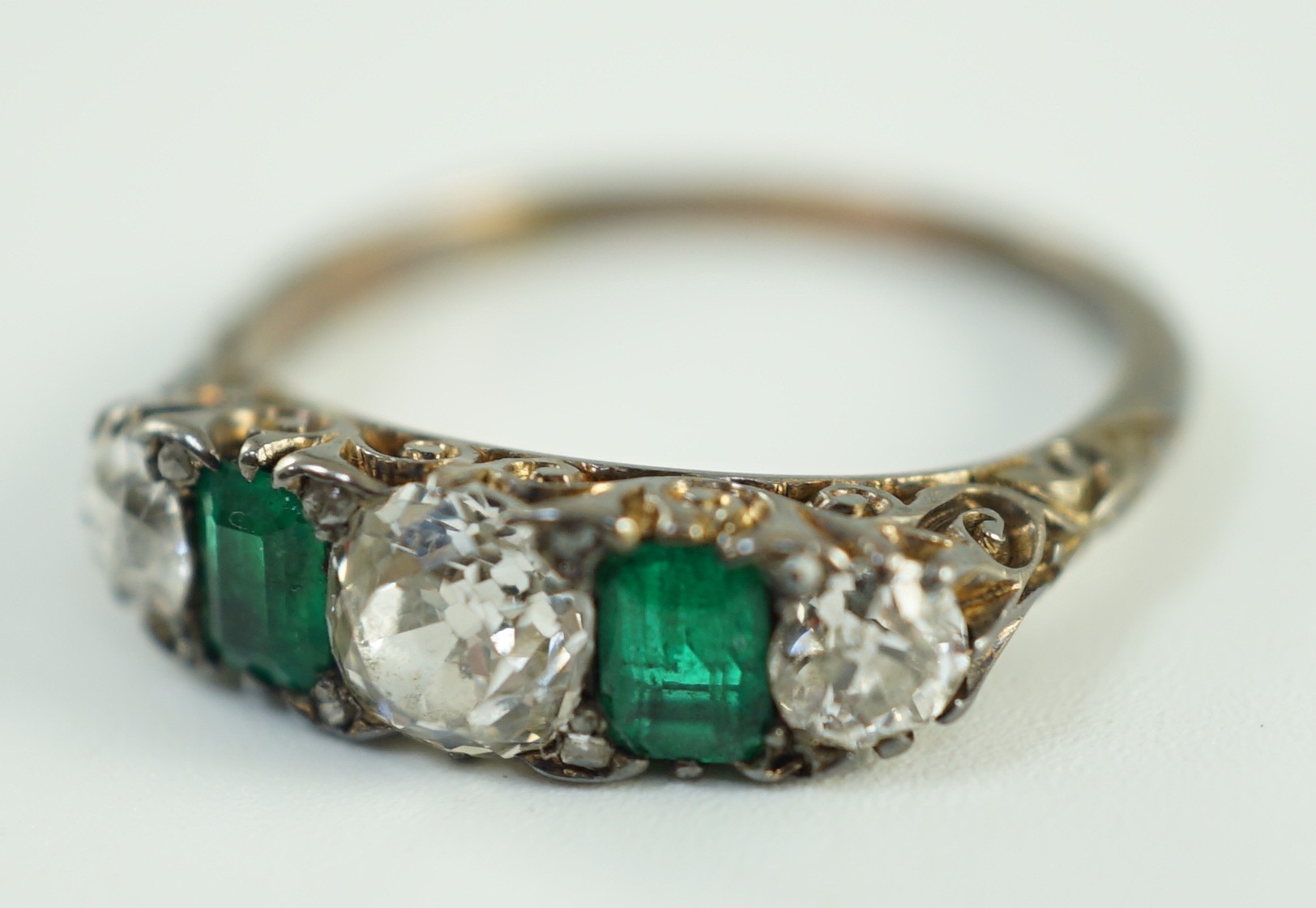 An early 20th century 18ct gold, three stone diamond and two stone emerald set half hoop ring, - Image 2 of 10