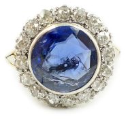 A gold and single stone round cut sapphire set dress ring, with diamond set border, size L/M,