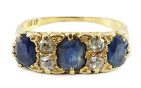 An early 20th century 18ct gold, three stone oval cut sapphire and four stone diamond spacer set