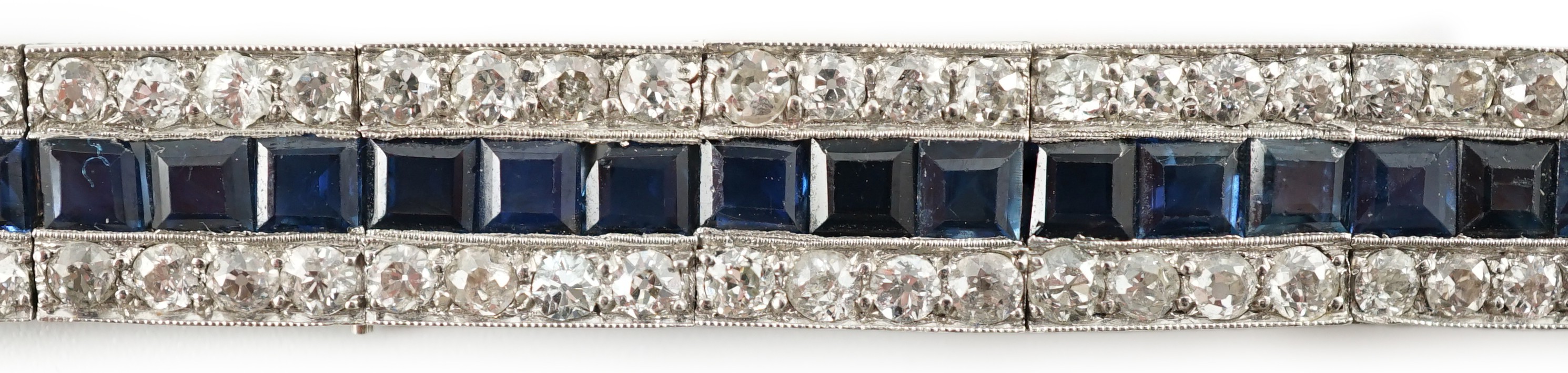 A 1920’s white gold, sapphire and diamond set triple line bracelet, with engraved setting and two