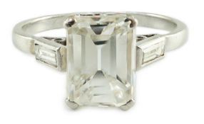 A platinum and single stone emerald cut diamond set ring, with baguette cut diamond set shoulders,