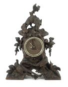 A 19th century Black Forest carved wood mantel timepiece, carved as a rocky mound with a fox looking
