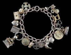 A 15ct? gold oval link charm bracelet, hung with seventeen assorted mainly 9ct charms, including