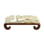 A Chinese white jade ‘dragon’ belt hook, 19th century, carved in high relief and openwork with a