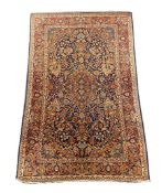 An early 20th century Kashan blue ground rug, with central lobed floral medallion within a triple