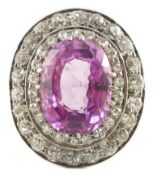 An early 20th century platinum, oval cut purple-pink sapphire and round cut diamond cluster set