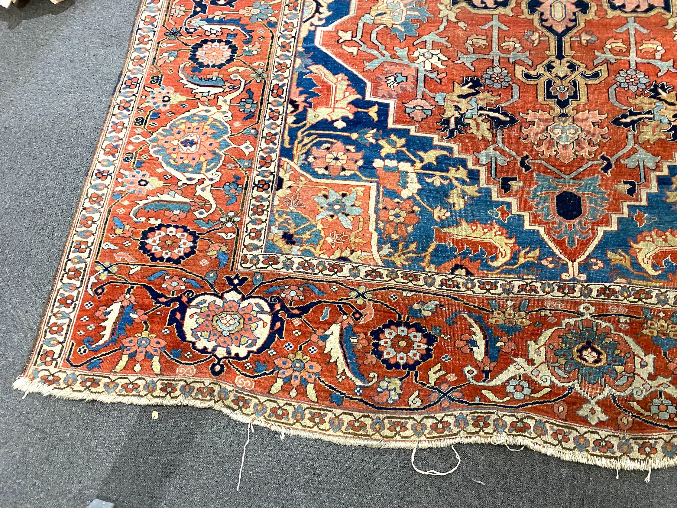 An antique Heriz brick red ground carpet, with large central floral medallion within a wide - Image 3 of 7