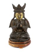 A Chinese late Ming bronze seated figure of Guanyin, with remnants of gilding to the face and hands,