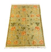 A Tibetan pale green ground carpet, with bold floral field, 250cm x 176cm***CONDITION REPORT***