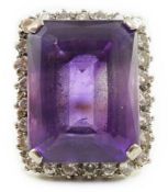 A large modern 18ct gold and emerald cut amethyst set dress ring, with diamond set border, the