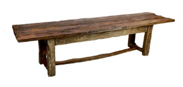 A rustic oak four plank top refectory table, constructed from old floorboards and other timbers,