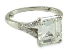 A platinum and single stone emerald cut diamond ring, with brilliant cut diamond set split