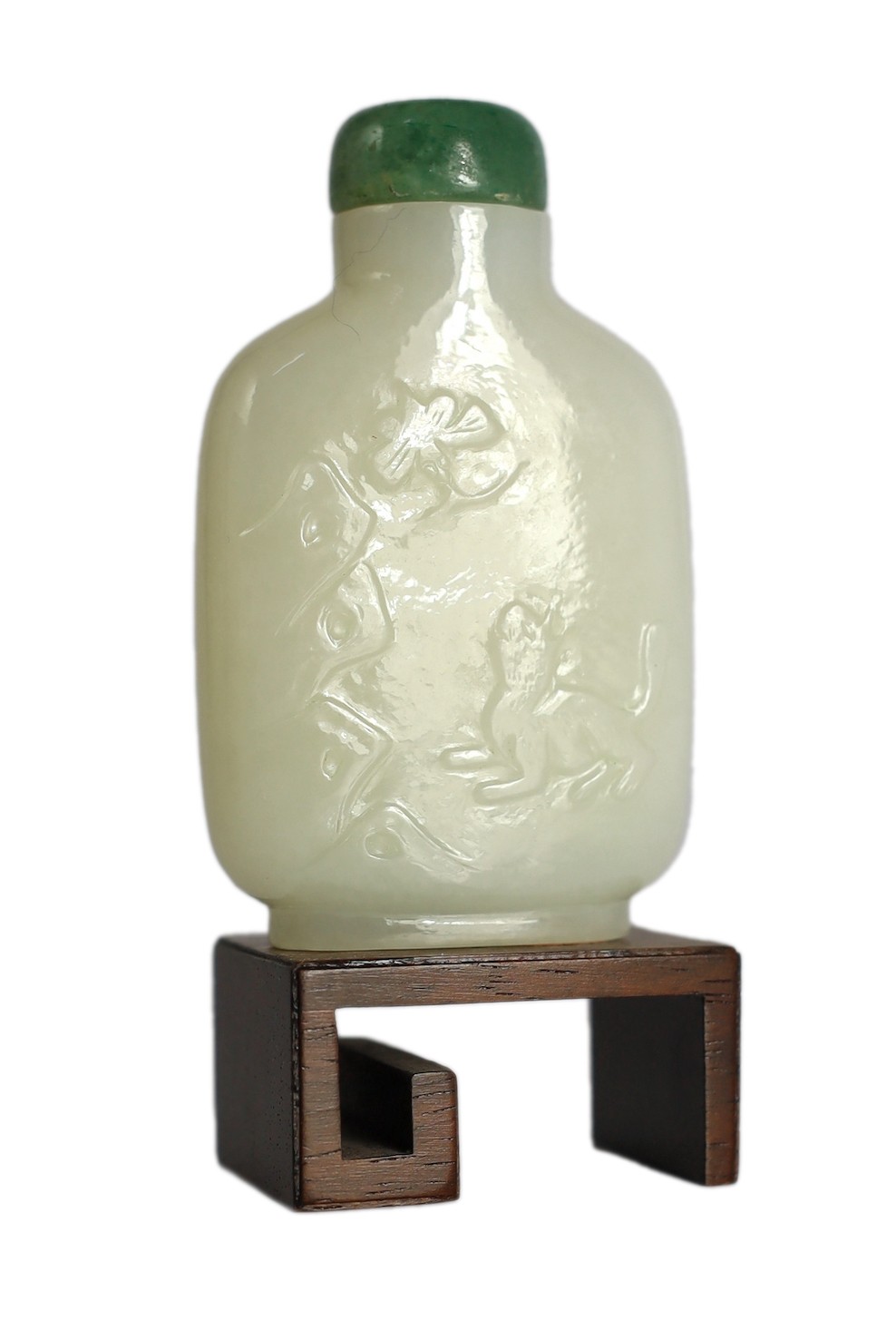 A Chinese white jade snuff bottle, 19th/20th century, carved in relief with a squirrel on rockwork