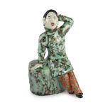 A Chinese enamelled porcelain figure of a Han Chinese woman, late 19th century, seated on a tree