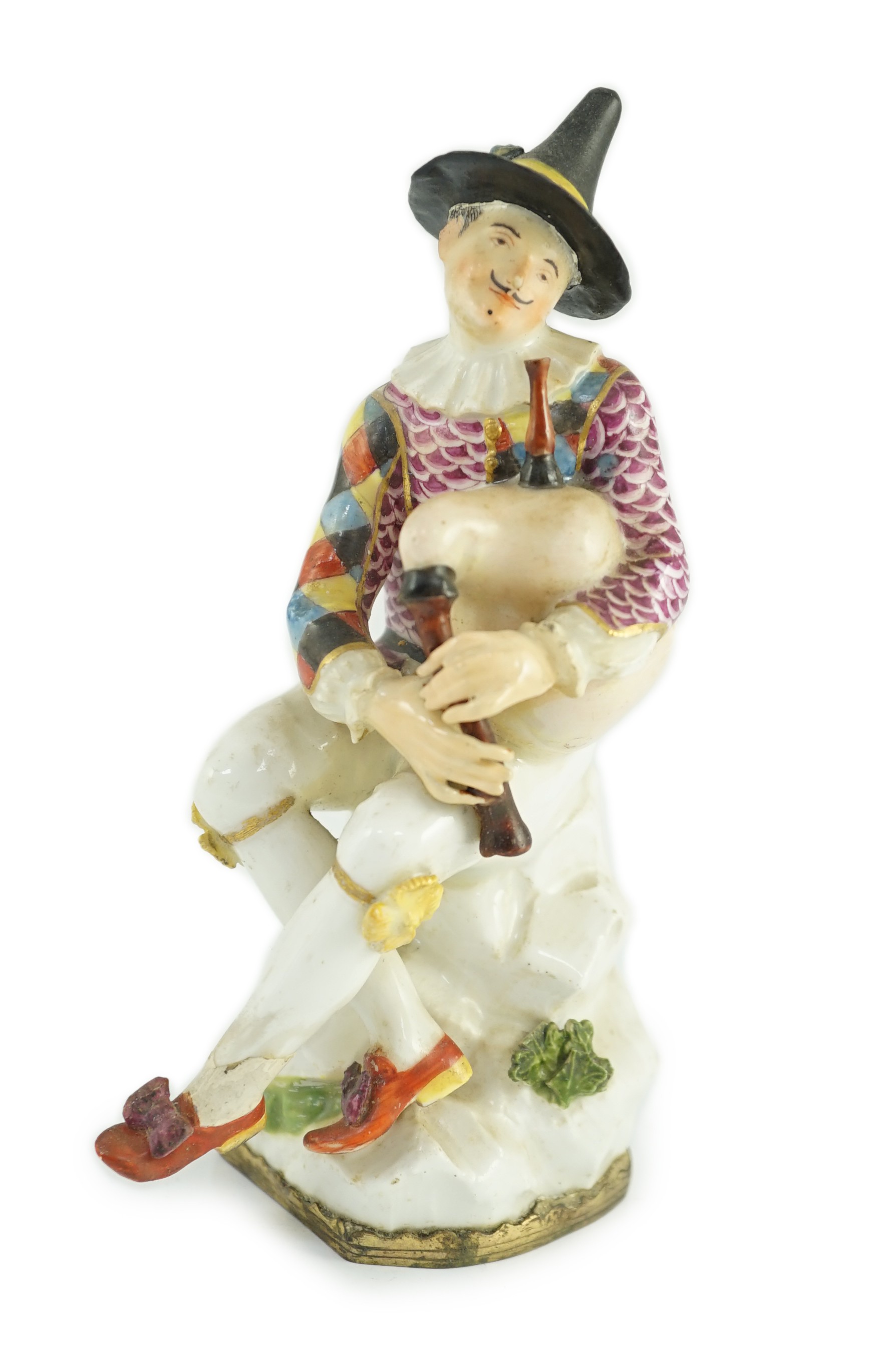 A Meissen porcelain figure of a seated bagpiper, mid 18th century, modelled by J.J. Kandler, wearing