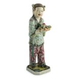 A Chinese enamelled porcelain figure of a boy attendant, early 20th century, the standing figure