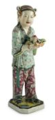A Chinese enamelled porcelain figure of a boy attendant, early 20th century, the standing figure
