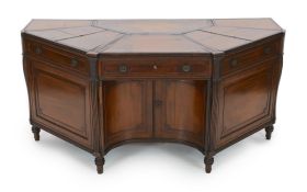 An unusual George IV mahogany kneehole desk, of demi-octagonal form, with segmented leather lined