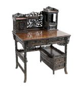 A late 19th century Chinese hongmu desk, carved and pierced throughout with floral motifs, the upper