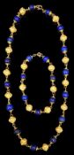 A 20th century Middle Eastern high carat gold canetile work bead and lapis lazuli bead set