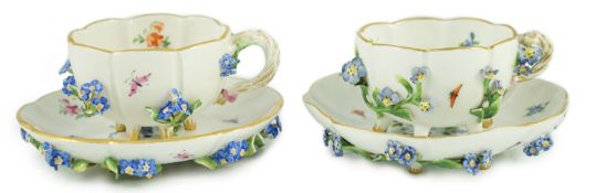 Two Meissen flower encrusted cups and saucers, 19th century, typically painted with flower spray,