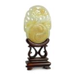 A Chinese white and russet skin jade oval plaque, 19th century, skilfully carved in relief and