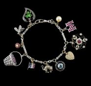 A French 18ct white gold circular and baton link charm bracelet, hung with eleven assorted charms,