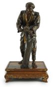A Japanese brown patinated and gilded bronze figure of a woodworker, in Miyao style, Meiji period,