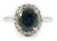 An 18ct white gold, sapphire and diamond set oval cluster ring, size M/N, gross weight 3.8