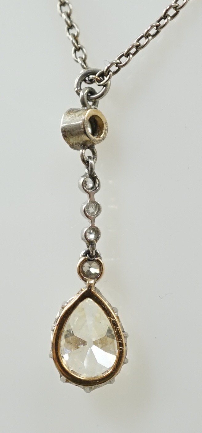 An early to mid 20th century white and yellow gold, six stone diamond set drop pendant, on a white - Image 4 of 5