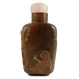 A Chinese brown jasper ‘sage’ snuff bottle, 19th century, carved in high relief with the figure of a