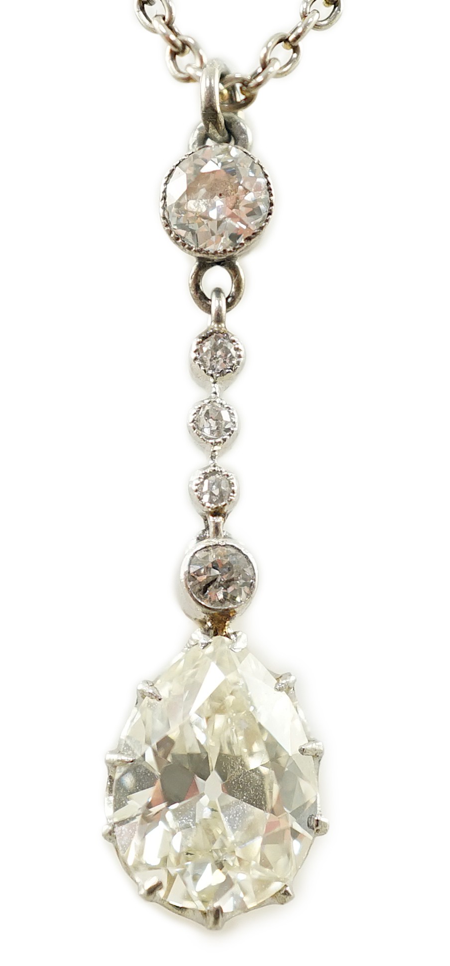 An early to mid 20th century white and yellow gold, six stone diamond set drop pendant, on a white