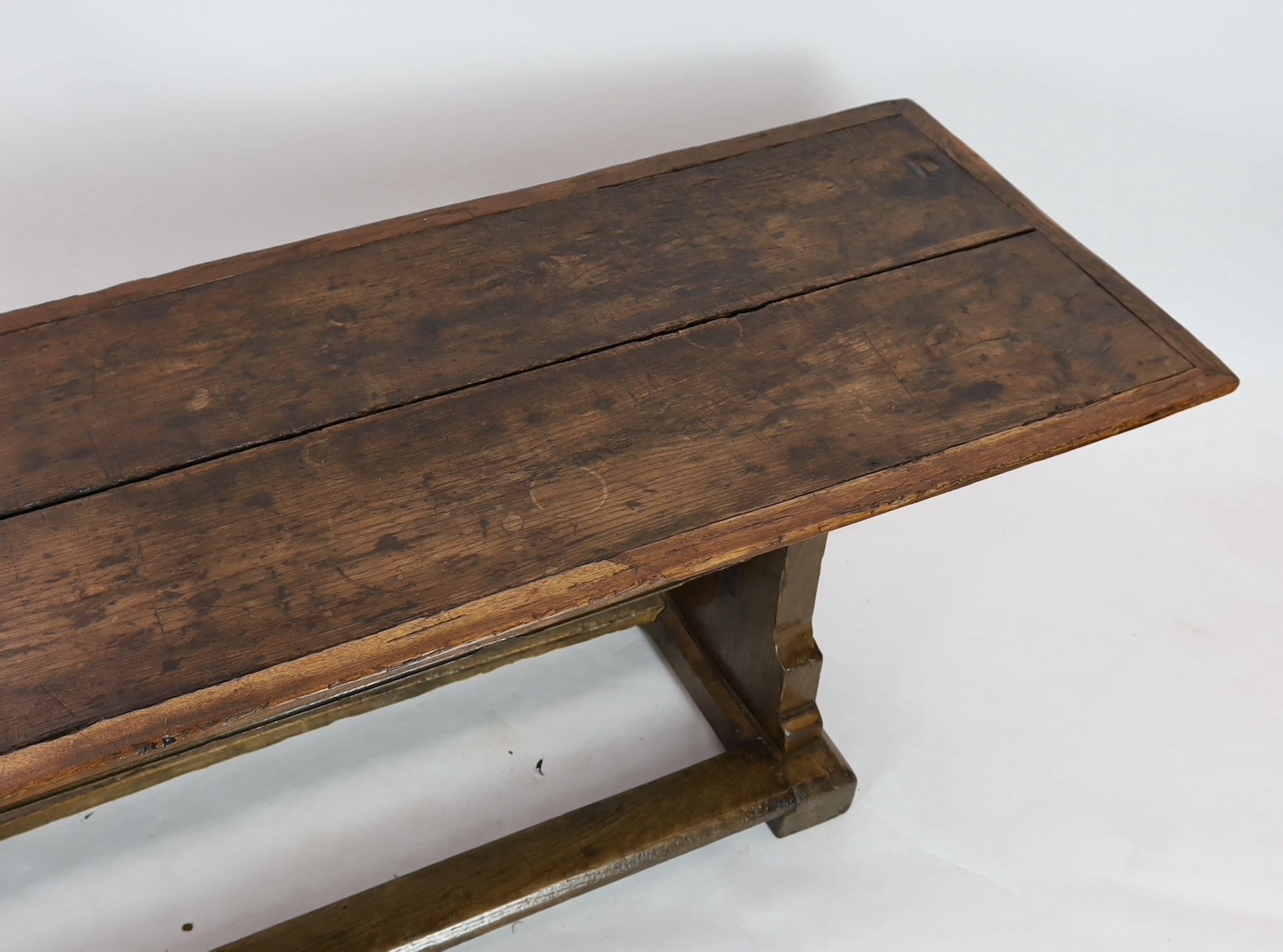 A narrow oak refectory table, part 17th century, the cleated twin plank top above trestle supports - Image 3 of 4