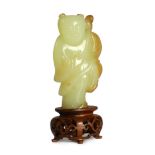 A rare Chinese yellow and russet jade figure of a boy holding a parrot, 18th/19th century,