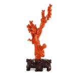 A Chinese carved coral figure of a flower fairy, 20th century, the figure holding a vase of