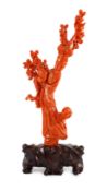 A Chinese carved coral figure of a flower fairy, 20th century, the figure holding a vase of