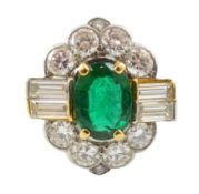 A modern platinum, oval cut emerald and baguette and round cut diamond set cluster ring, of shaped